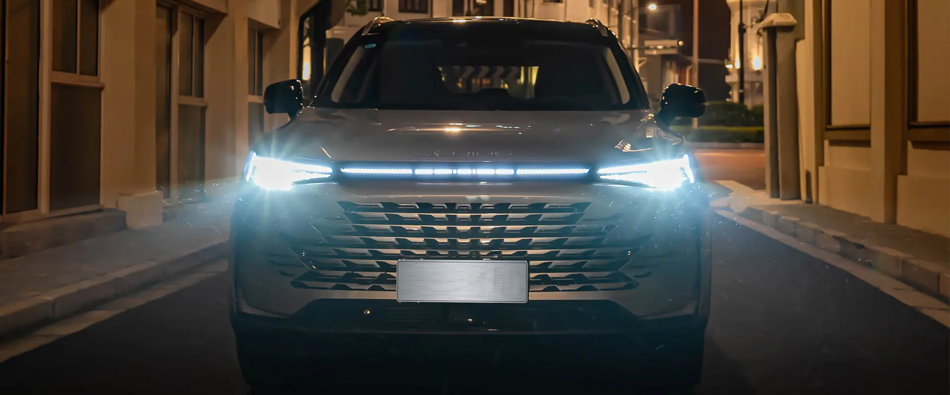 BAIC Beijing X75 SUV in grau metallic fährt mit LED-Scheinwerfern in der Stadt bei Nacht